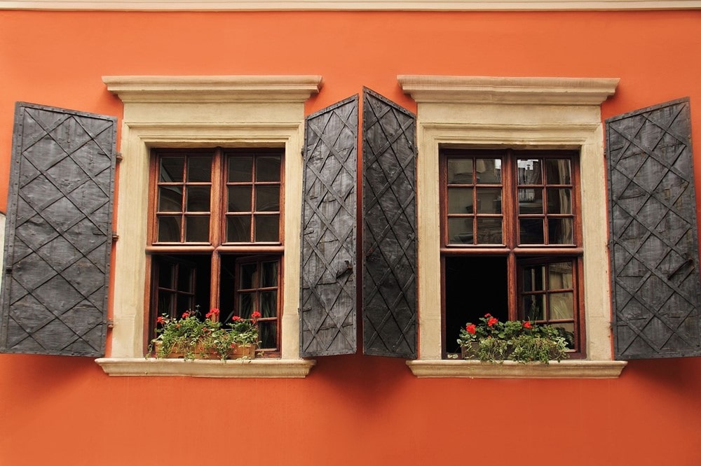 Kunststofffenster in Holzoptik an orangefarbenem Haus