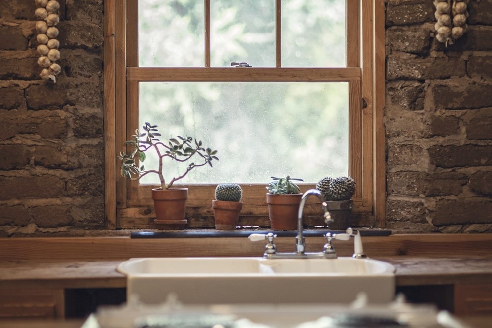 Küchenfenster hinter Spüle und Pflanzen in Holzoptik
